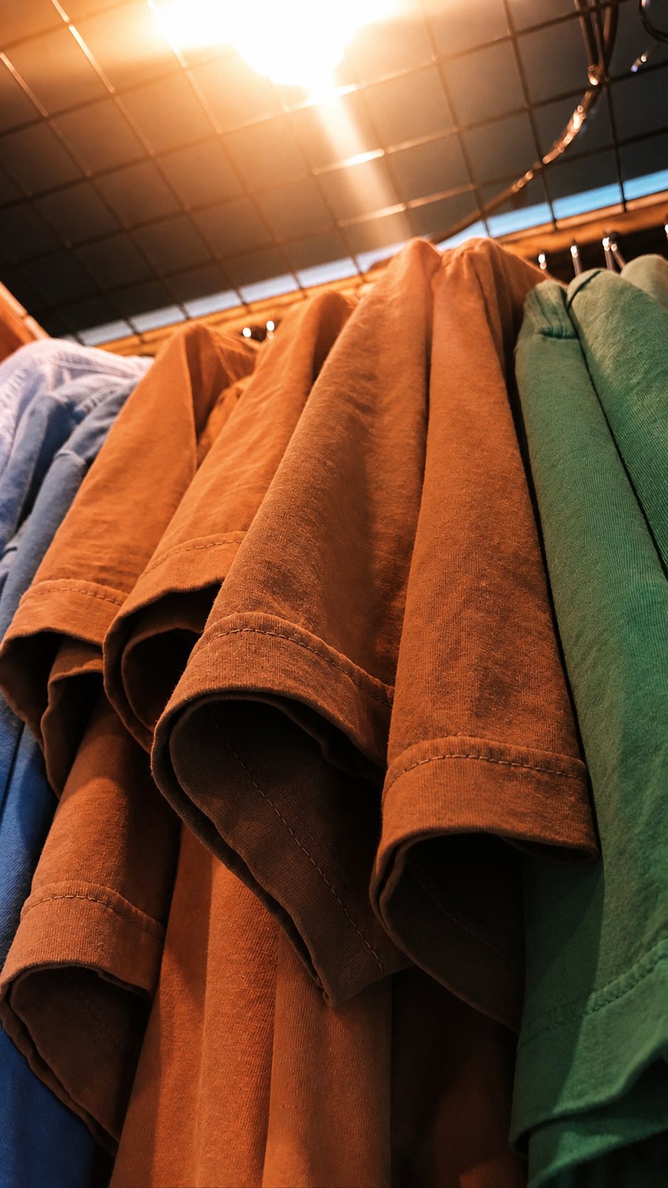 Camisetas DMATTEX dobradas em várias cores